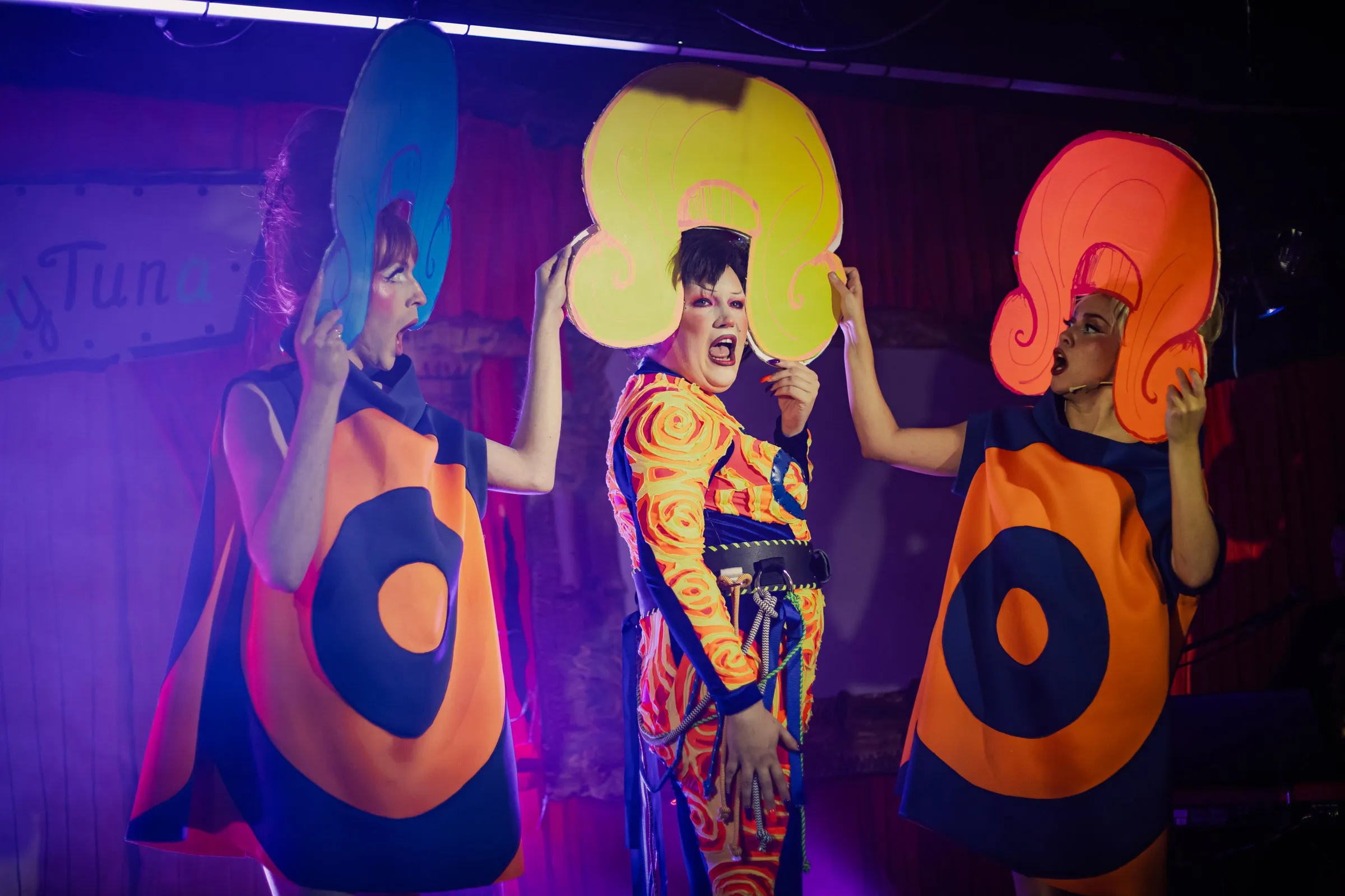 Ms Sharon Le Grand with two dancers in giant wigs